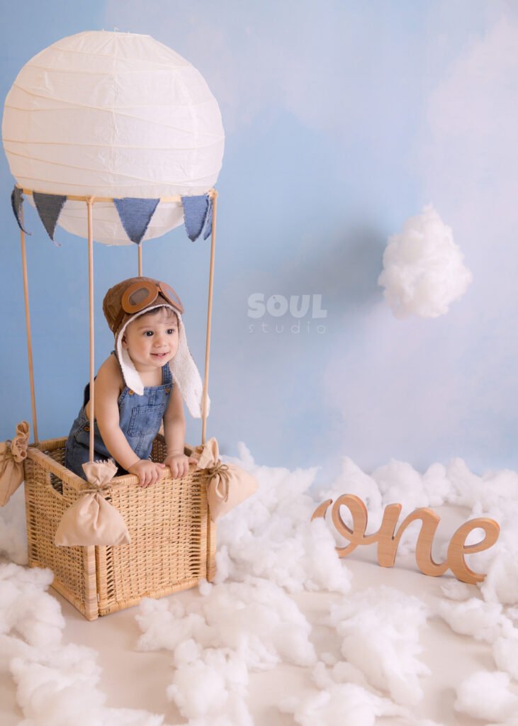one year old first birthday cake smash baby toddler hot air balloon setup clouds blue sky photography photoshoot photo session