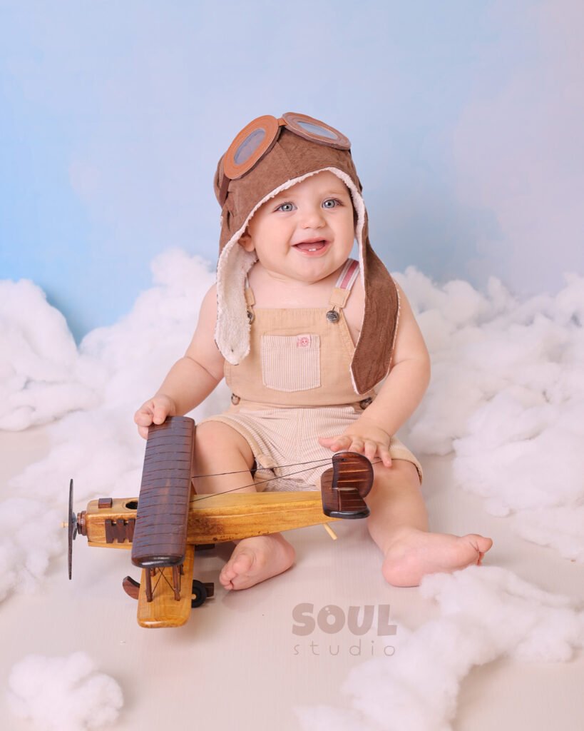 airplane baby sitter sky clouds 1 year old aviator hat pilot blue boy