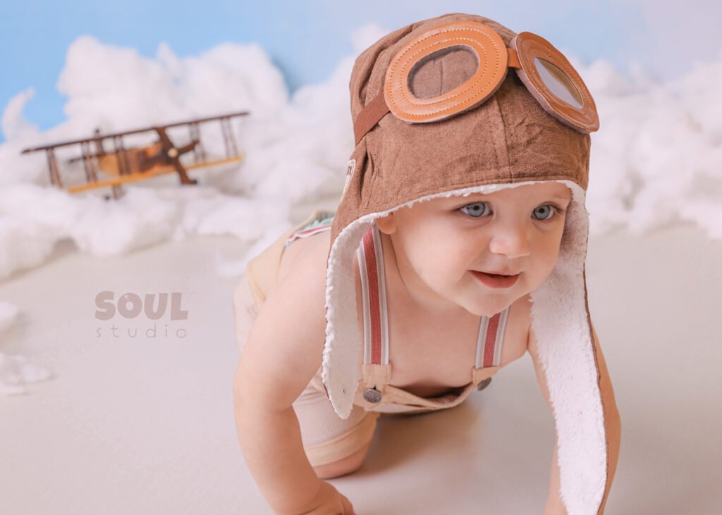 airplane baby sitter sky clouds 1 year old aviator hat pilot blue boy
