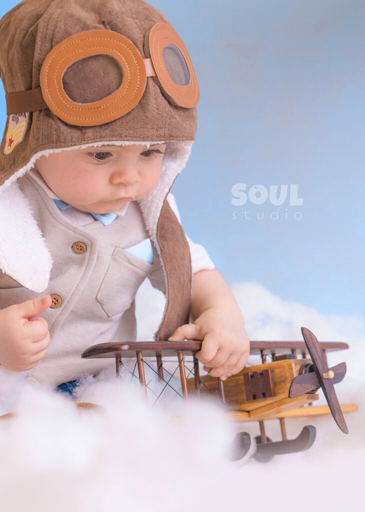 airplane baby sitter sky clouds 1 year old aviator hat pilot blue boy