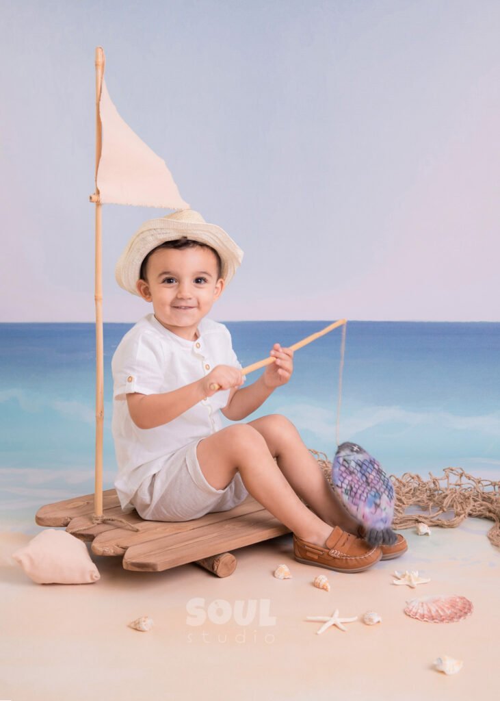 fishing sea floating boat baby boy sitter non-sitter beach starfish seashells blue sky ocean sailor setup fish rod