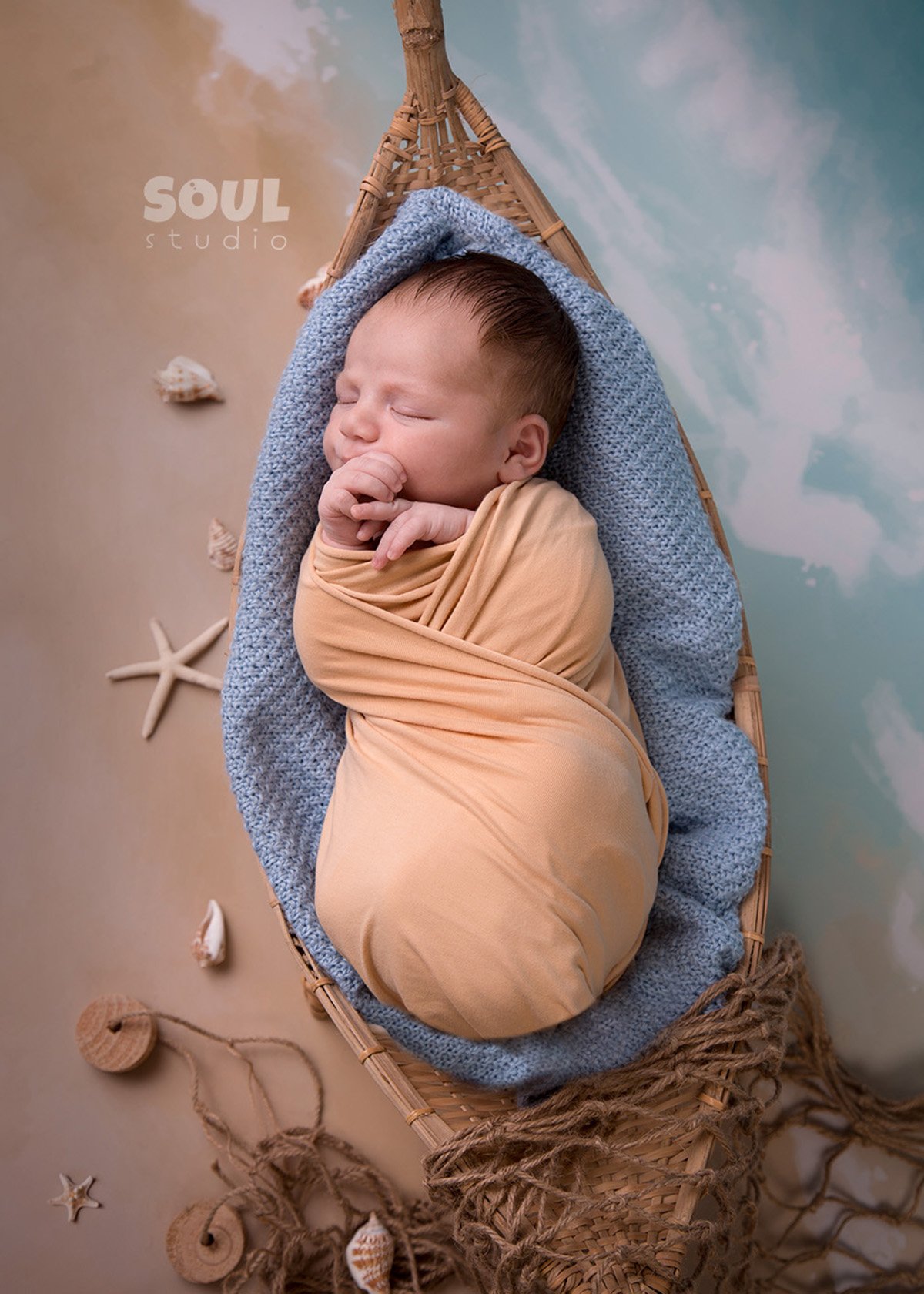 Newborn sleeping in a little fishing boat setup at Soul Studio