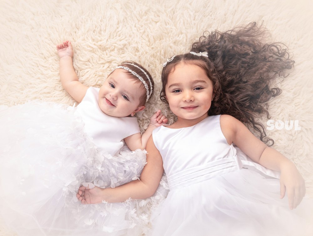 Baby girl and her big sister in white dresses at Soul Studio, Amman