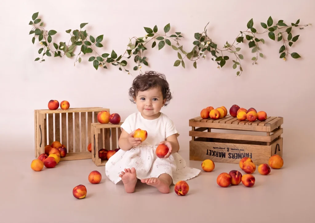 Baby in a peach season setup at a seasonal fruits photoshoot in Amman