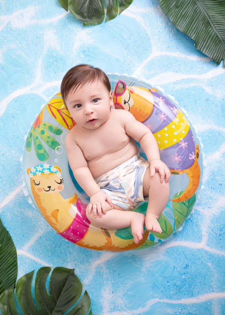 Happy baby splashing in a summer pool setup — baby photography session in Amman, Jordan